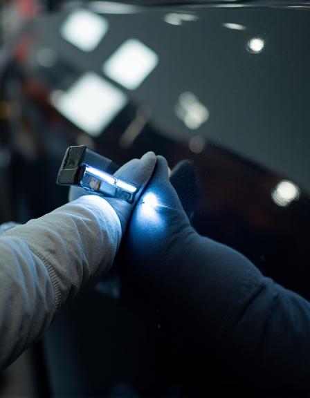 Detailer inspecting paint quality